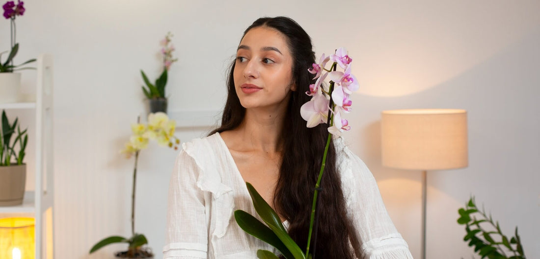 Frau in einem Wohnzimmer mit Orchidee im Arm